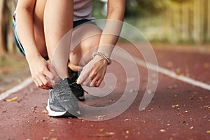 woman tying her shoes on running track. Jogging girl exercise motivation heatlhy fit living