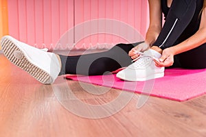 Woman tying the laces of her gym shoes