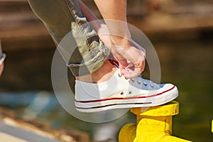 Woman tying laces in sneakers outdoors