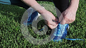 Woman tying shoe laces. Athlete laces up sneakers. Female tying her exercise shoes. Sport running concept. Fitness exercises