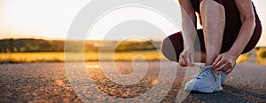 Woman tying shoelace on her running shoes