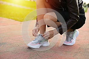 Woman tying shoelaces on her sneakers