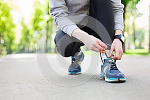 Woman tying shoes laces before running