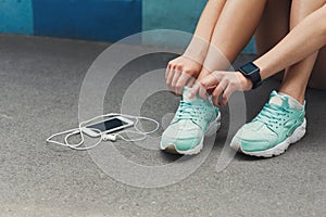 Woman tying shoes laces before running top view