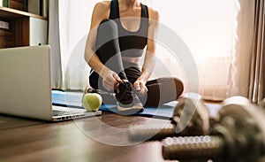 Woman tying shoes.A person running in tracksuit tying her shoelaces