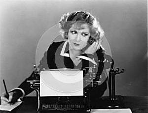 Una mujer sobre el máquina de escribir sobre el teléfono 