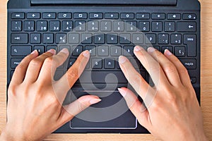 Woman typing in her laptop keyboard