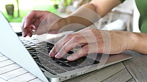 Woman typing on the keyboard of her computer laptop