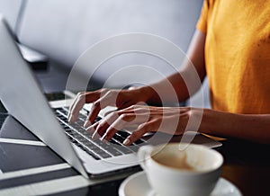 Woman typing on laptop at the cafe