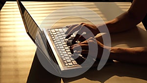 The woman is typing on a laptop. Close-up of female hands on the keyboard.