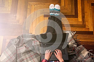 Woman typing on laptop on the floor, top view. The concept of remote work