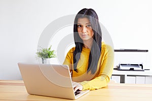 Woman typing on laptop in home office