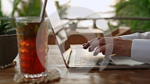 Woman typing on laptop keyboard in cafe. Writer creates a poem. Person composing email using notebook in outdoor