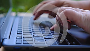 Woman is typing on laptop keyboard, selective focus, working in evening at laptop of his house, hands closeup, concept of remote