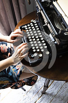Woman typing on an old typewriter.