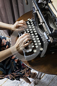 Woman typing on an old typewriter.