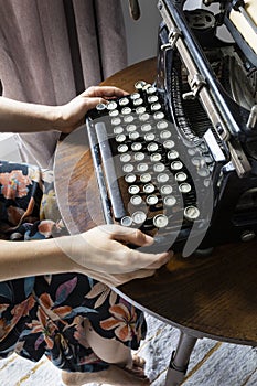 Woman typing on an old typewriter.