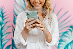 Woman typing text message on smart phone in a cafe.