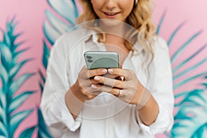 Woman typing text message on smart phone in a cafe.