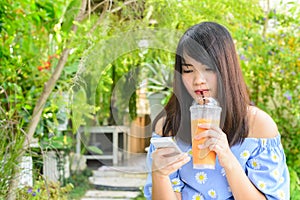 Woman typing text message on smart phone in a cafe. Cropped image of young woman sitting at a table with a coffee using phone.