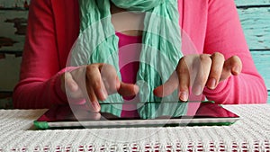 Woman typing text on virtual keyboard in internet online on tablet