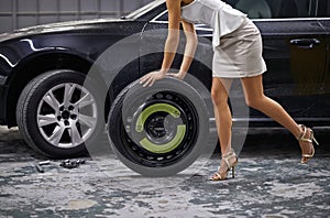 Woman, tyre and change for car repair with heels in parking garage or wheel failure for puncture, auto mechanic or