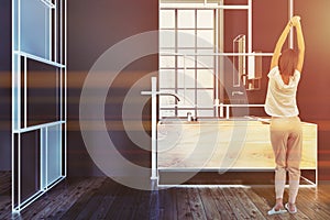 Woman in an ultra modern black bathroom interior