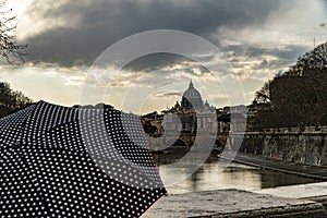 Woman with umbrella in front of the Papal Basilica of St. Peter, west of River Tiber in Rome, Italy