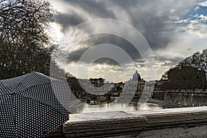 Woman with umbrella in front of the Papal Basilica of St. Peter, west of River Tiber in Rome, Italy