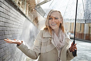 Woman, umbrella and hand with rain in city, walking and surprise for splash, weather and happy in winter. Person, wow