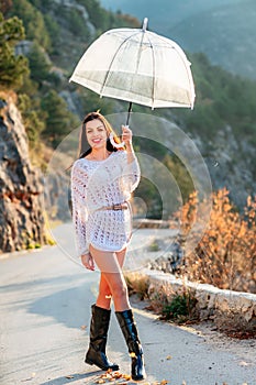 woman umbrella leaves , She holds him over her head, autumn leaves are falling out of him. Beautiful woman in a dress