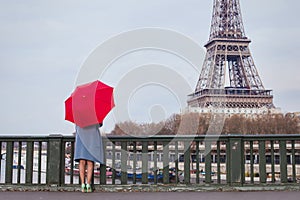 Woman with umbrella looking at Eiffel tower in Paris, travel to France