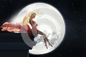 Woman with umbrella over full moon background