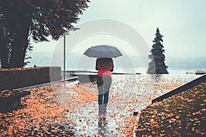 Woman with an umbrella in the park in autumn day