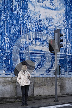 Woman with an umbrella on Santa Catarina main street in Porto, Portugal.