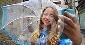 Woman, umbrella and selfie in rain, street and happy with web blog update on holiday in Barcelona. Girl, person and