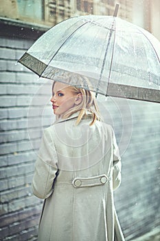 Woman, umbrella and walking with rain in city, thinking or ideas with cover, weather and memory in winter. Person