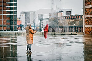 Woman with umbrella walking on the street during bad weather photo