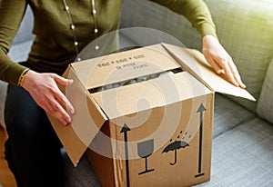 Woman unboxing good cardboard box