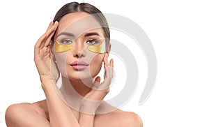 Woman with under eye collagen gold pads, beauty model girl face with healthy fresh skin. Skin care concept, anti-aging mask