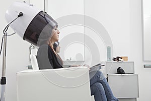 Woman Under Hooded Dryer Machine In Hair Salon