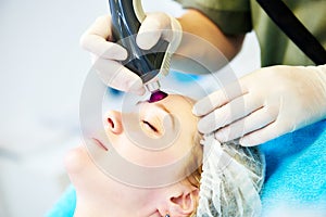 Woman under laser cosmetology procedure