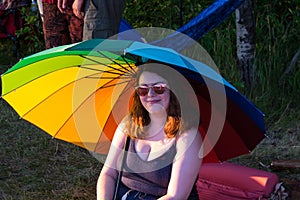 Woman under rainbow sunshade Winnipeg Folk Festival July 2019