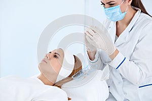 Woman undergoing face biorevitalization procedure in salon.