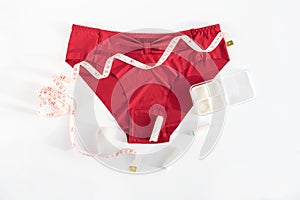 Woman underpants, tampons and metric measuring tape. Concept of premenstrual syndrom, critical days, abdominal pain and