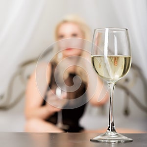 woman in underwear in a bed waiting for her lover. Focus on glass of champagne. Dating concept