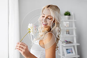 Woman in underwear with peony flower at window