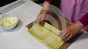 A woman unfolds a biscuit cake. Preparation of biscuit rolls. Stages of preparation.