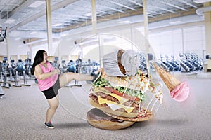 Woman with unhealthy foods in the fitness center