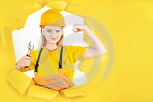 Woman in uniform builder holding metal wrench